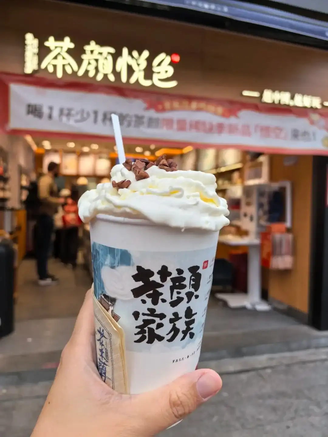 A cup of Shengsheng Oolong with white cream topping outside a Chayan Yuese shop