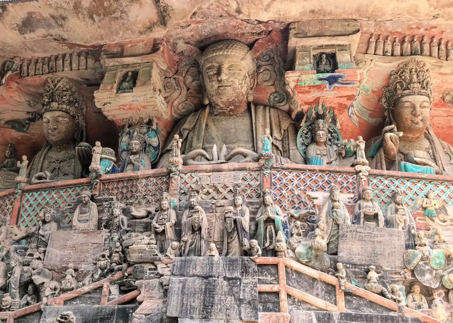 Dense colored figures carved into a cliff at Dazu