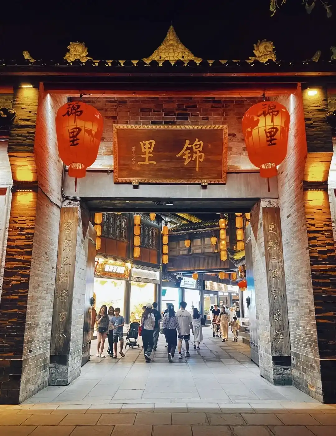 Illuminated entrance arch at Jinli after dark
