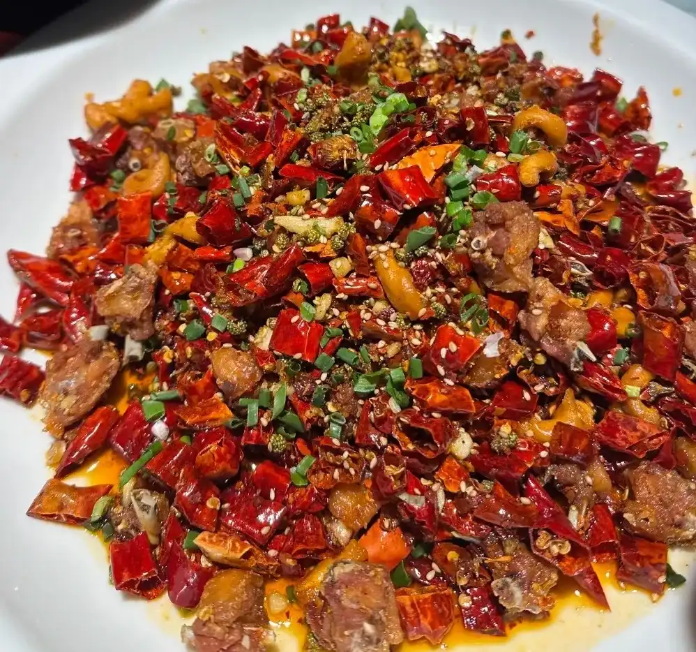 Small golden chicken pieces among dried chillies and Sichuan pepper