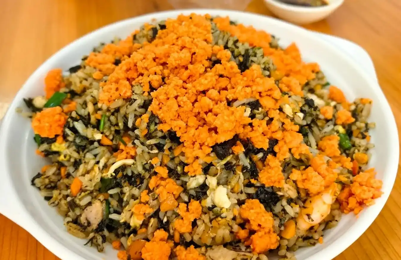 Separate golden grains of fried rice topped with orange sea urchin and seaweed