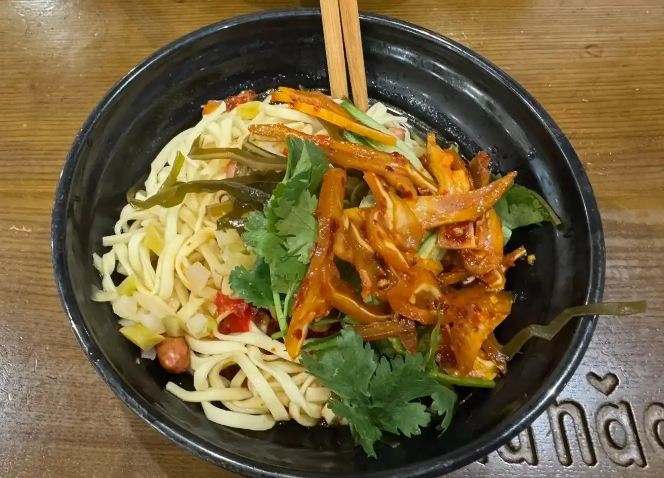 Cold noodles topped with sliced pig ear, kelp, pickles and coriander