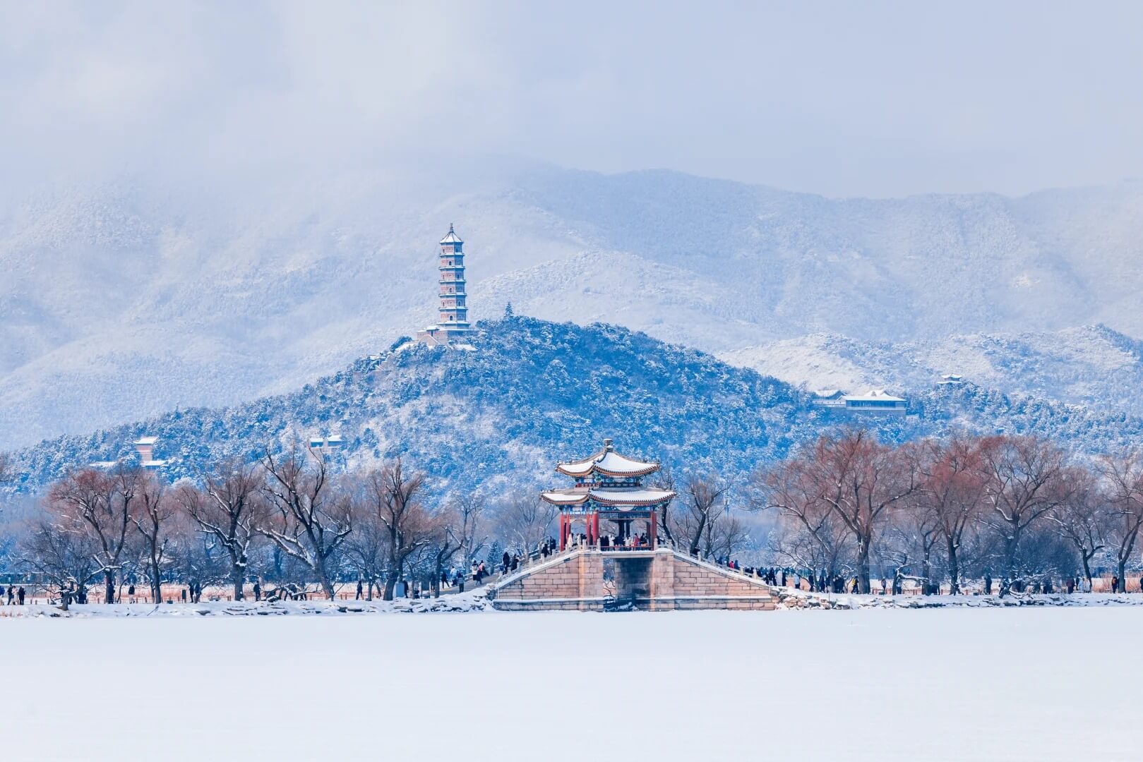 Snowy lakeshore and distant hills
