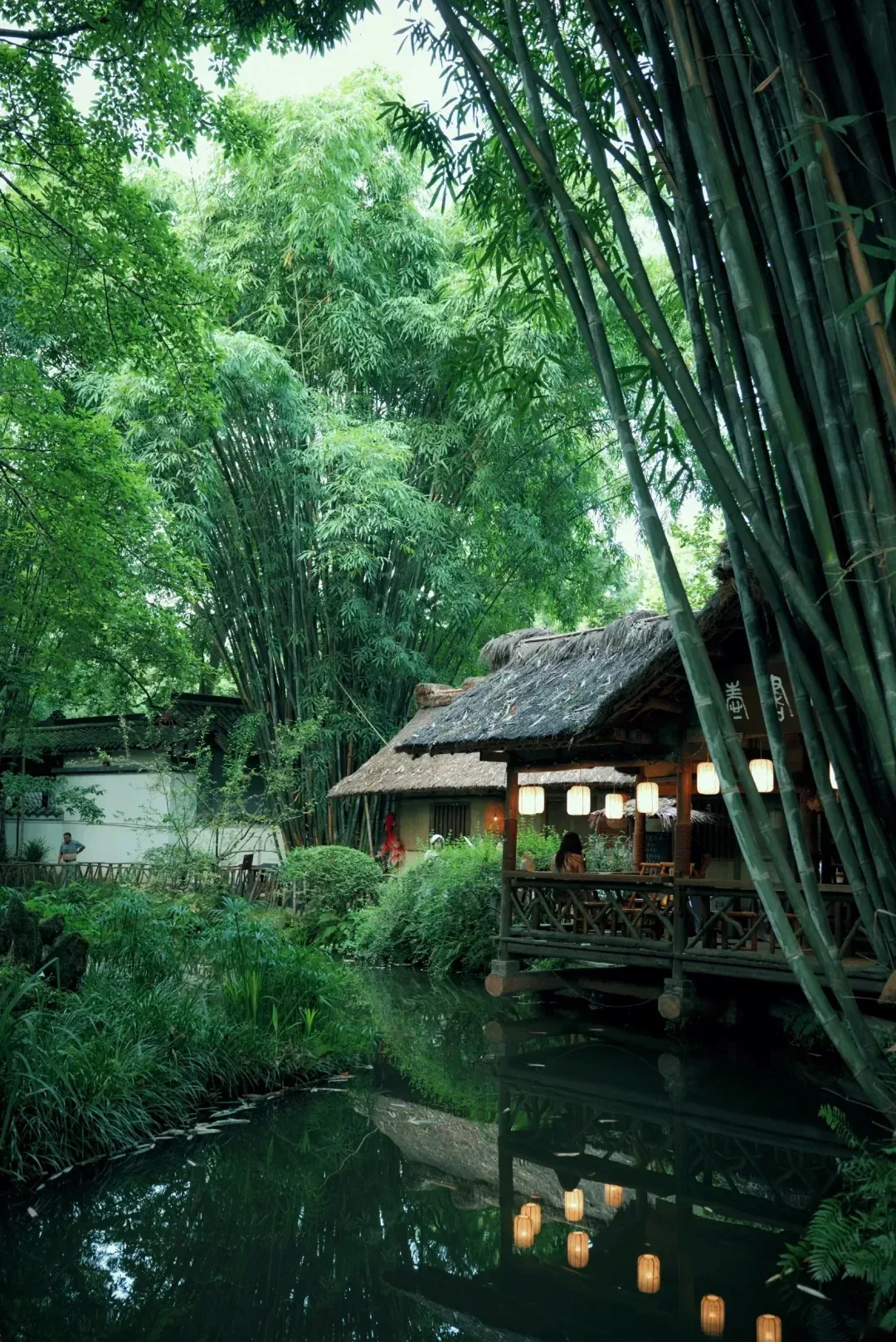 Thatched cottage beside bamboo and water
