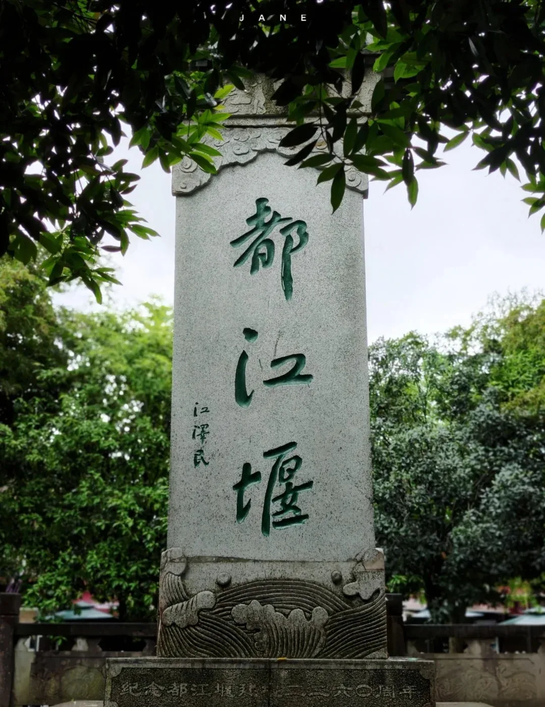 Stone marker inscribed Dujiangyan among trees