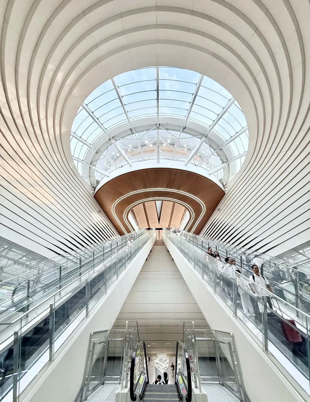 Large skylight, escalators, and several passenger levels inside Chongqing Jiangbei Airport