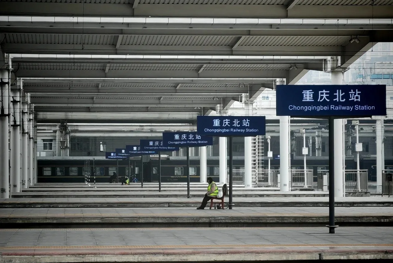 Multiple platforms, trains, and Chongqing North station signs