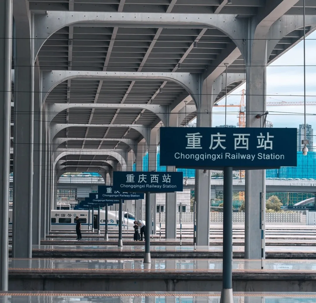 Multiple platforms, station signs, and trains at Chongqing West