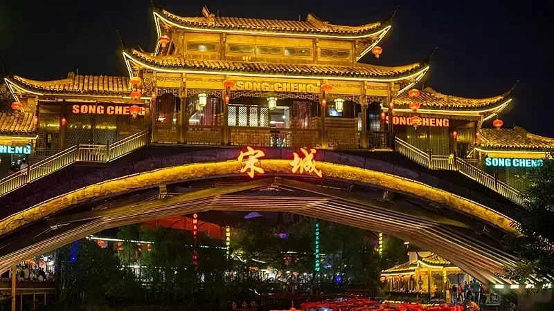 The illuminated Hangzhou Songcheng entrance and its reflection