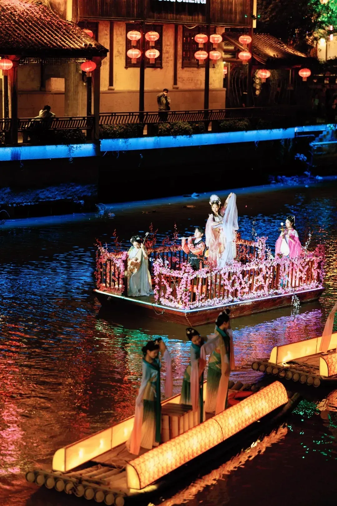 Costumed performers on illuminated boats in a Songcheng water show