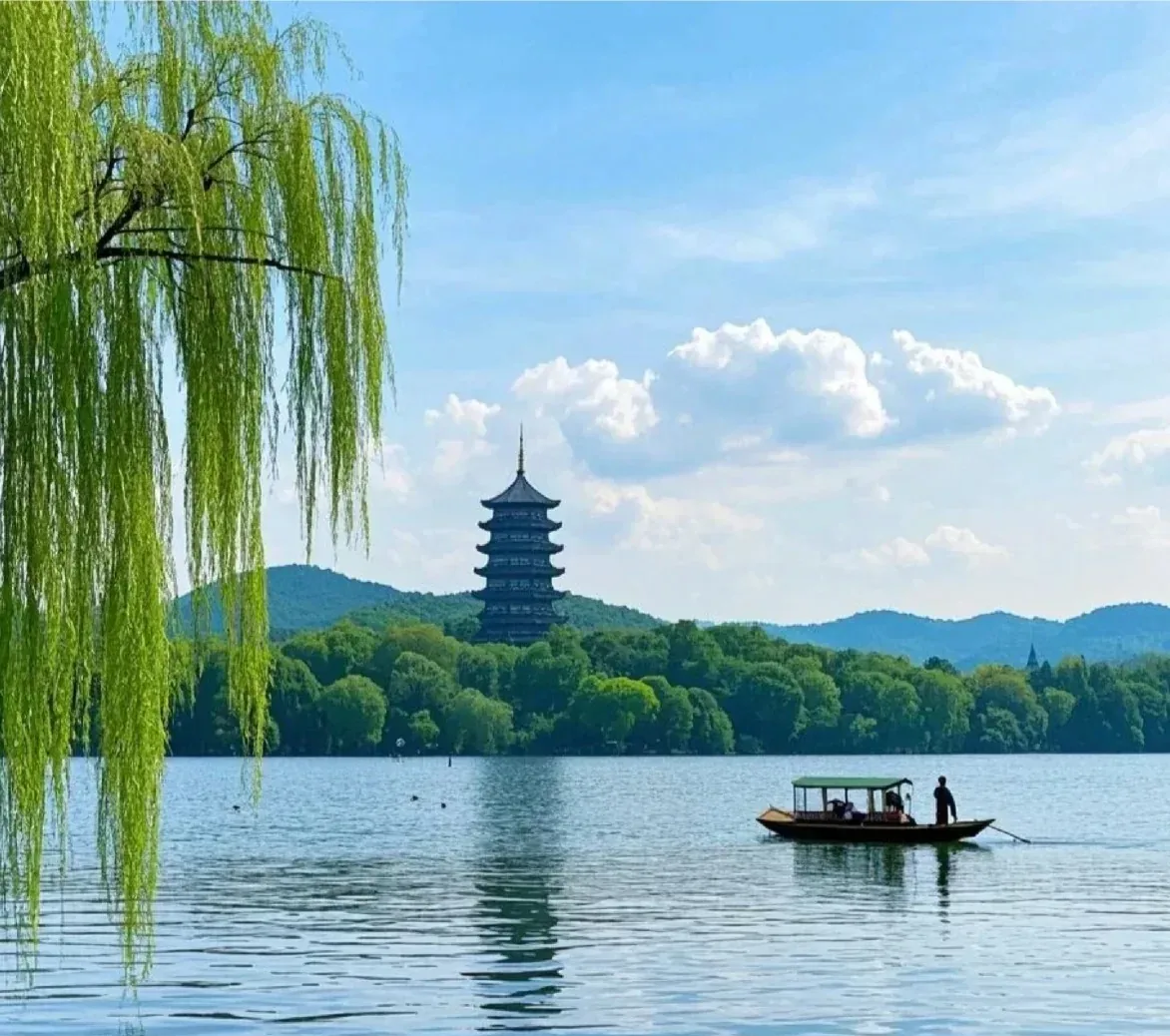 A hand-rowed boat and Leifeng Pagoda across West Lake
