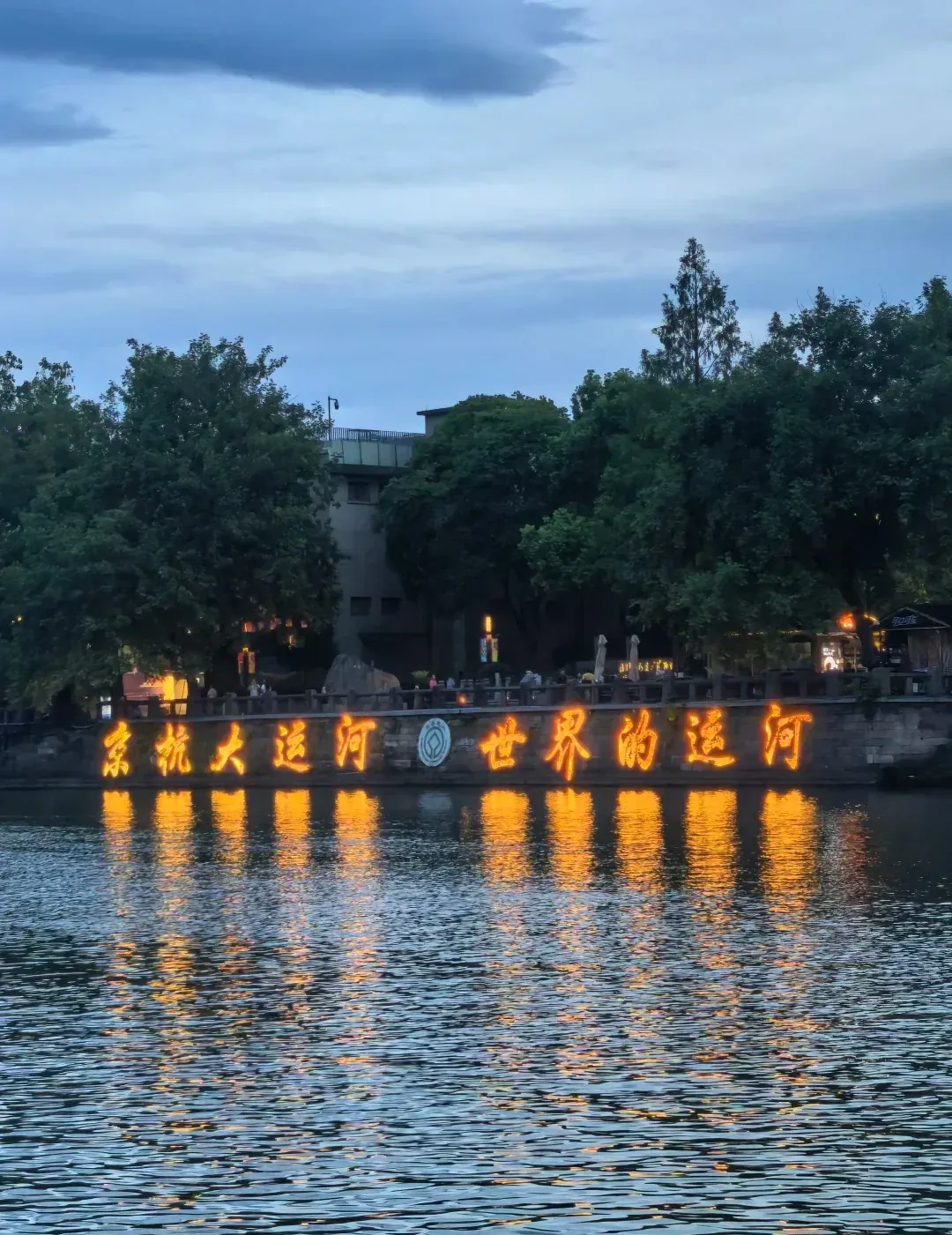 The "World's Canal" light sign along the water at night