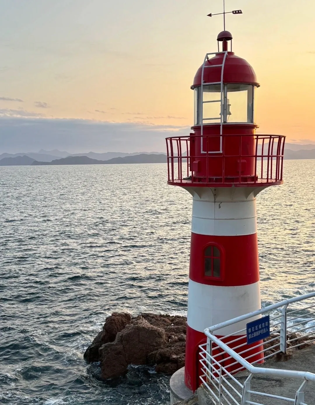 Red-and-white lighthouse at sunset on the Beizaijiao coast