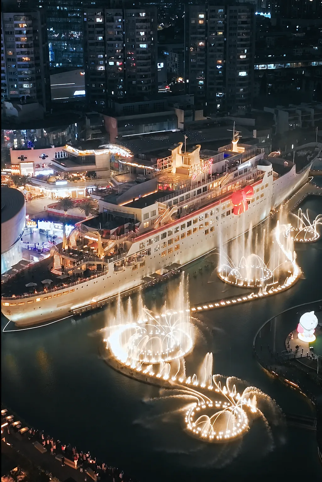 Minghua ship and fountain at Sea World after dark