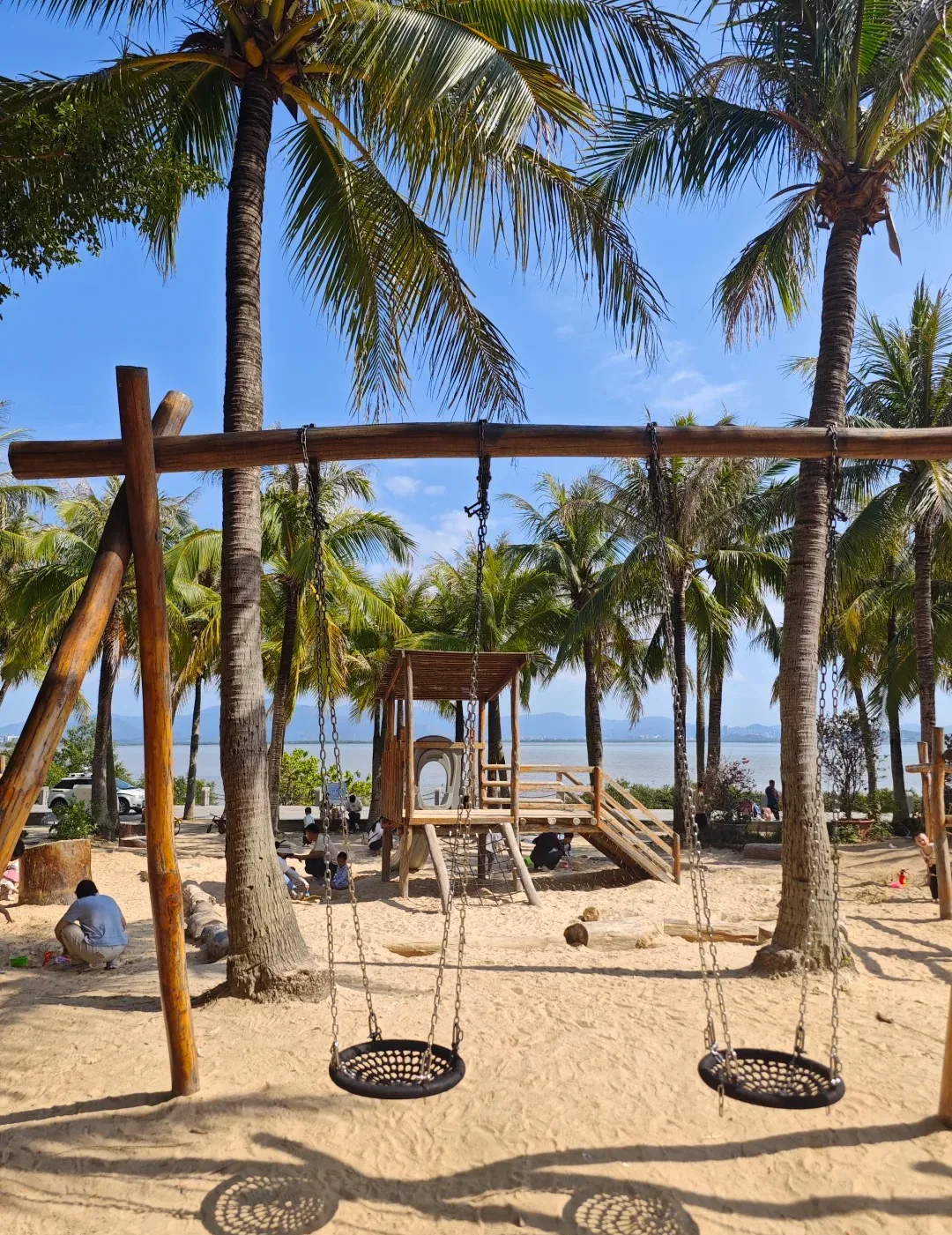 Palms and a sandy activity area beside Shenzhen Bay