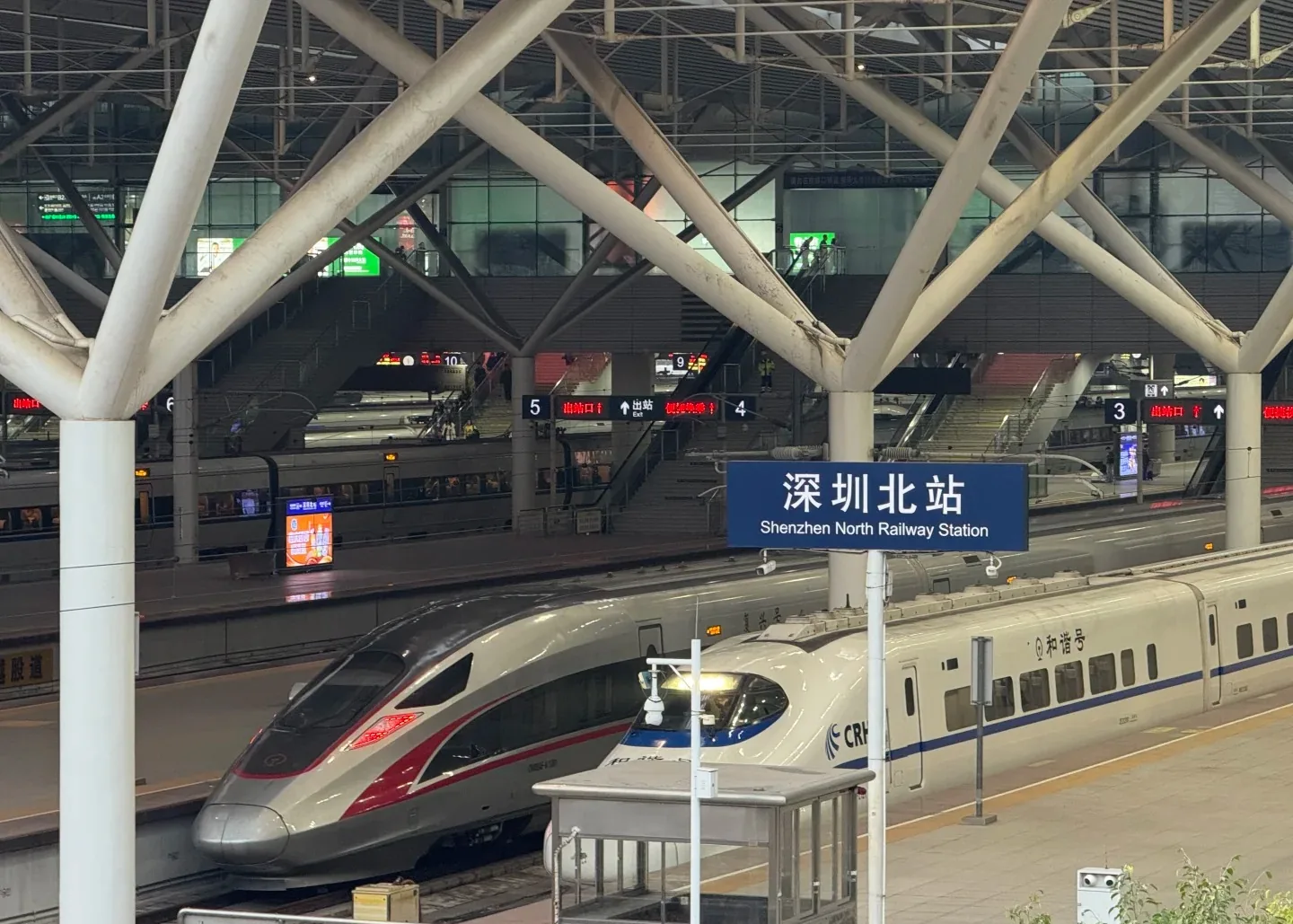 Elevated waiting hall and blue gate signs inside Shenzhen North Railway Station