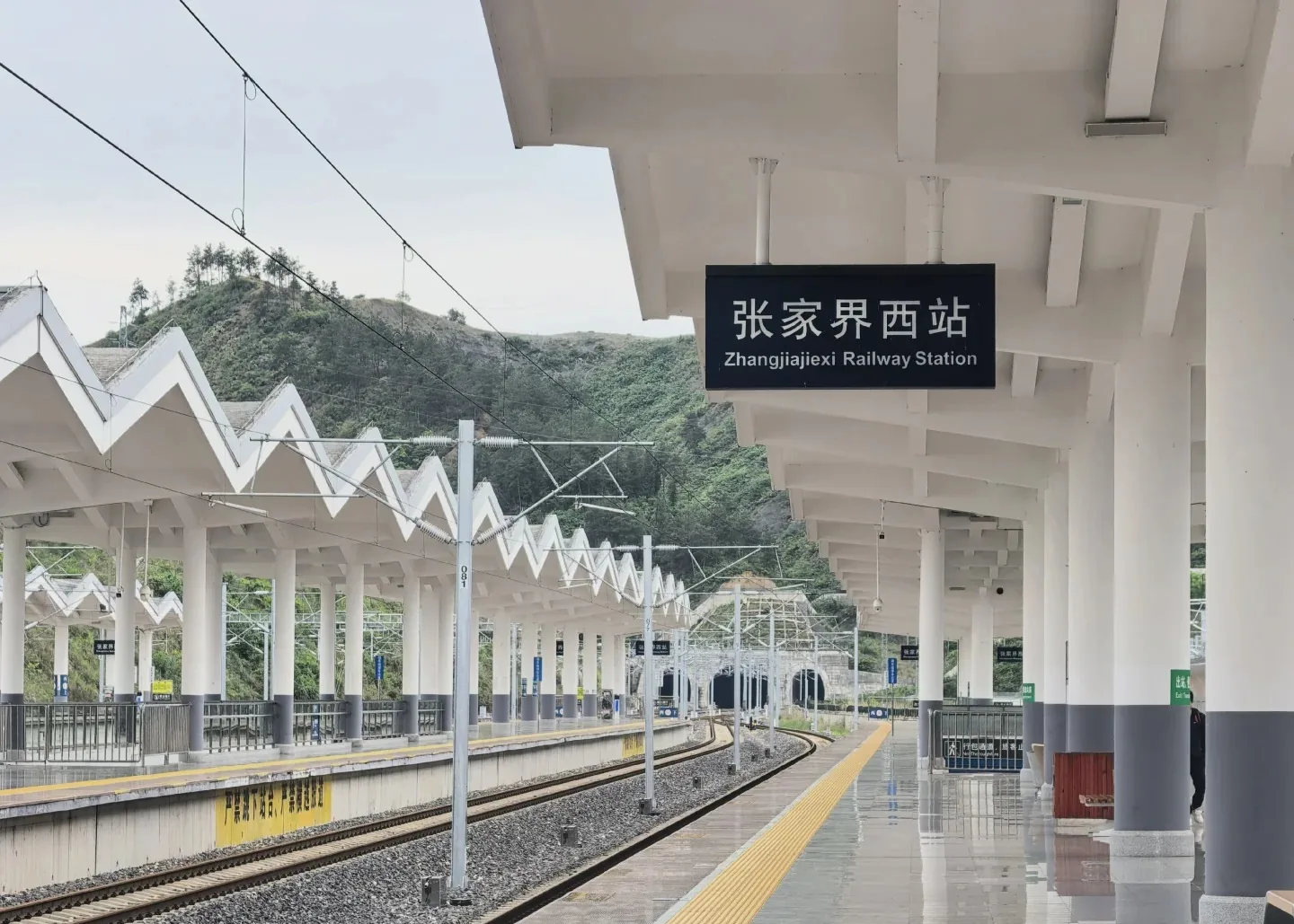 Platforms, station sign and mountain tunnel at Zhangjiajie West Railway Station